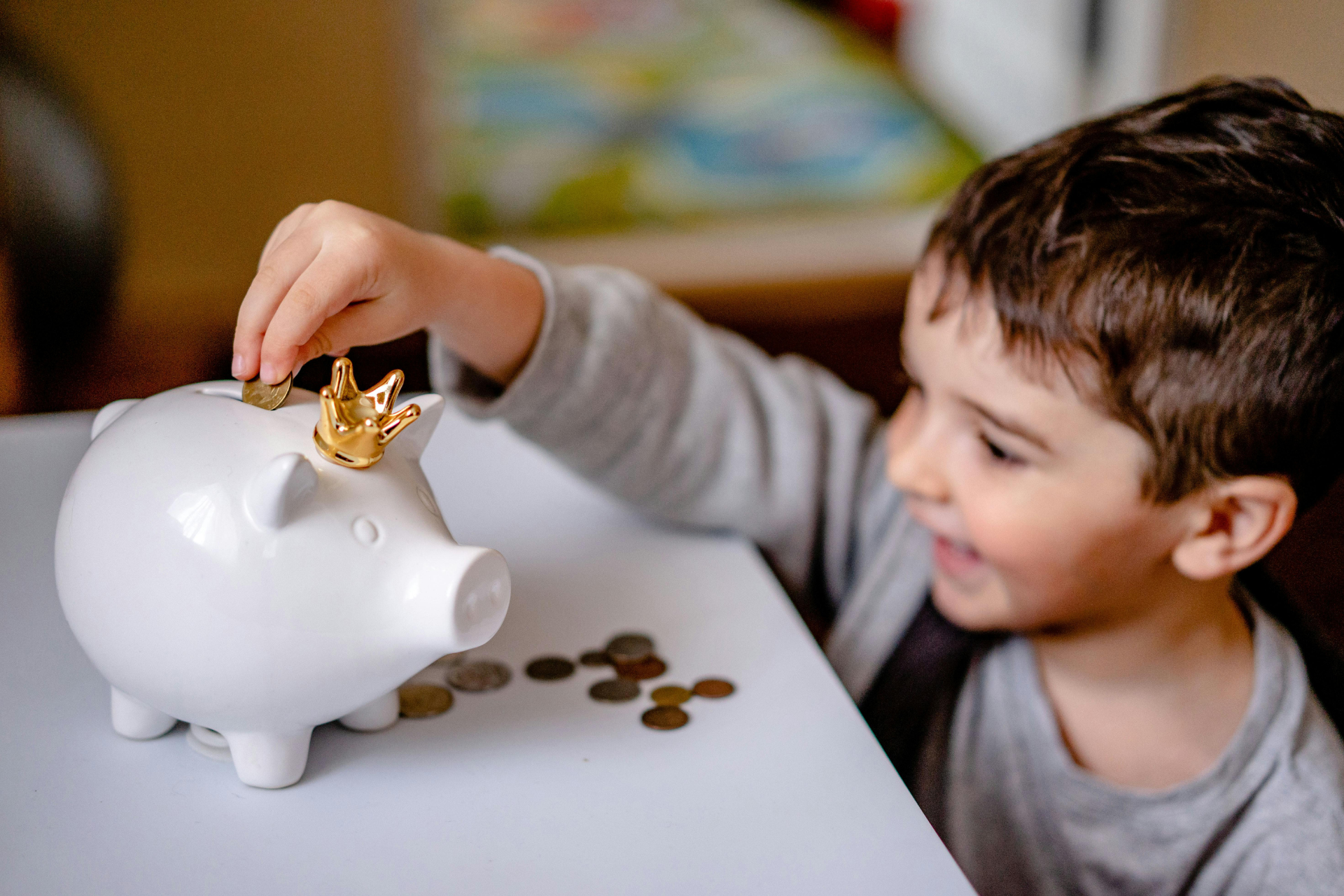edukacja finansowa dziecka dziecko odkładające monety do skarbonki